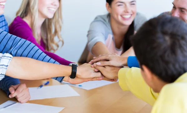 Grupp gymnasieelever med hand på toppen — Stockfoto