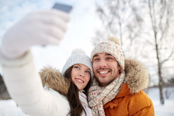 Gelukkige paar nemen selfie door smartphone in de winter — Stockfoto