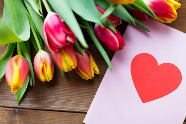 Close up of flowers and greeting card with heart — Stock Photo, Image