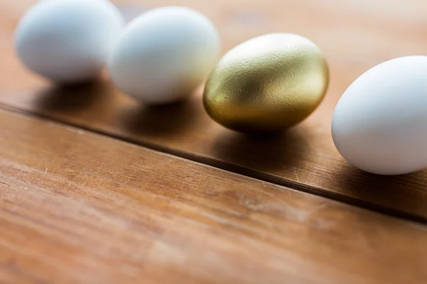 Close up of golden and white easter eggs on wood — Stock Photo, Image