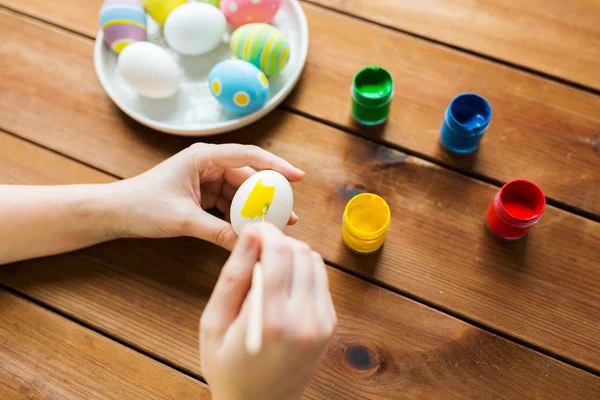 Primer plano de las manos de la mujer para colorear huevos de Pascua — Foto de Stock