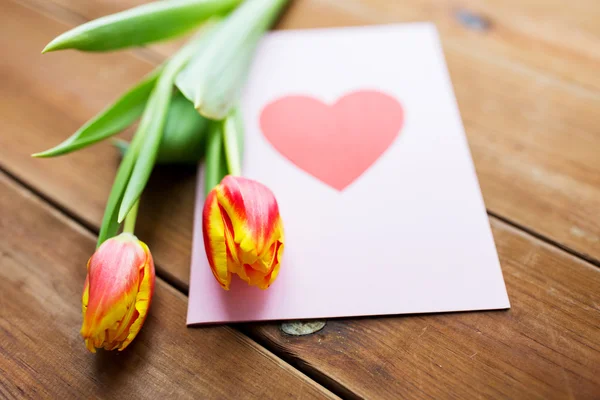 Primo piano di fiori e biglietto di auguri con cuore — Foto Stock