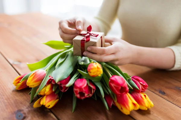 Primer plano de la mujer con caja de regalo y flores de tulipán — Foto de Stock