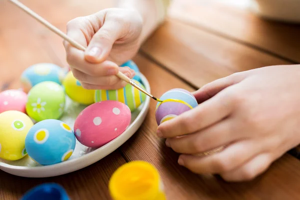 Primer plano de las manos de la mujer para colorear huevos de Pascua — Foto de Stock