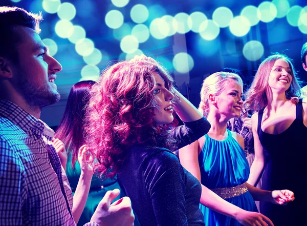 Smiling friends dancing in club Stock Picture