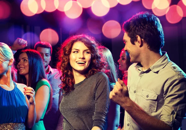 Smiling friends dancing in club Stock Photo