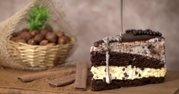 Schmelzende weiße Schokolade wird auf einen honigsüßen Brownie mit Nüssen und Baiser auf einem Holztisch gegossen