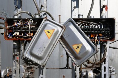 Kablolu eski paslı elektrik trafo kutusu.