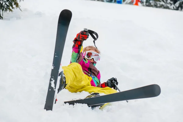 Парень лежит в снегу с лыжами — стоковое фото