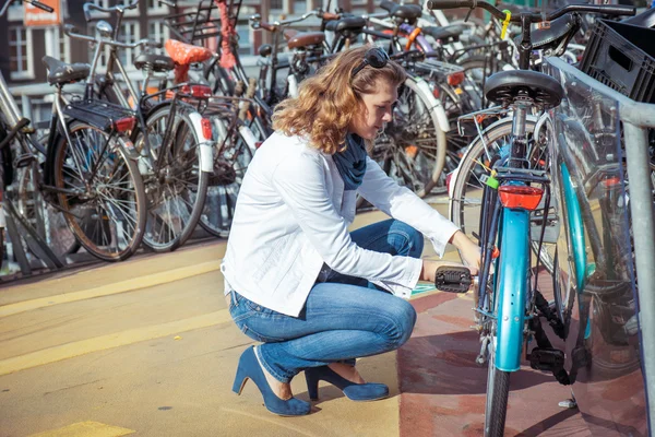 Frau entriegelt Fahrrad — Stockfoto