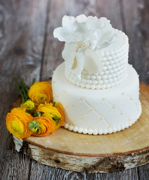 Kaka täckt med vit fondant och smörblommor. — Stockfoto