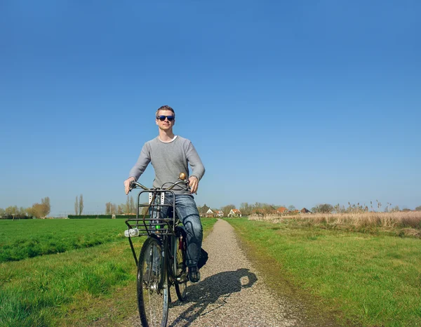 L'uomo in bicicletta in campagna — Foto Stock