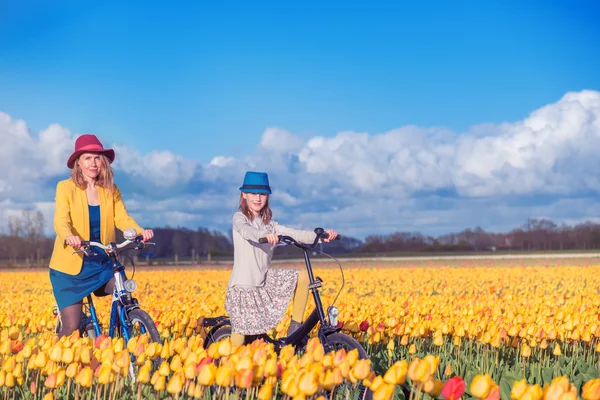 Madre e hija en un campo de tulipanes amarillos — Foto de Stock