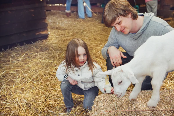Niño y padre domesticando a un niño cabra —  Fotos de Stock
