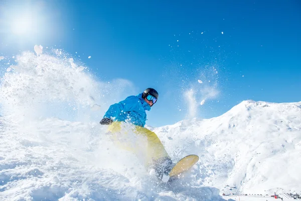 Snowboarder cavalcando lungo il pendio — Foto Stock