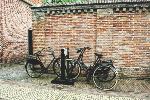 Bicicletas perto de uma parede de tijolo — Fotografia de Stock