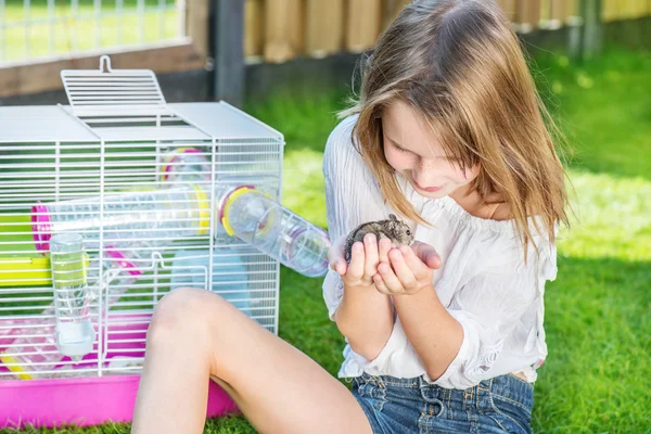 Flicka med en hamster i palms — Stockfoto