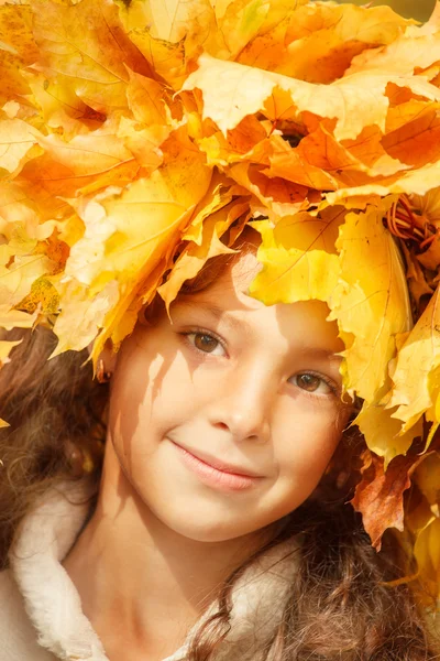 Mädchen mit gelben Herbstblättern auf dem Kopf — Stockfoto