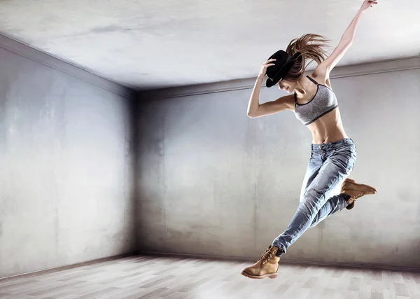 Bailarina atlética saltando sobre un fondo de pared de hormigón —  Fotos de Stock