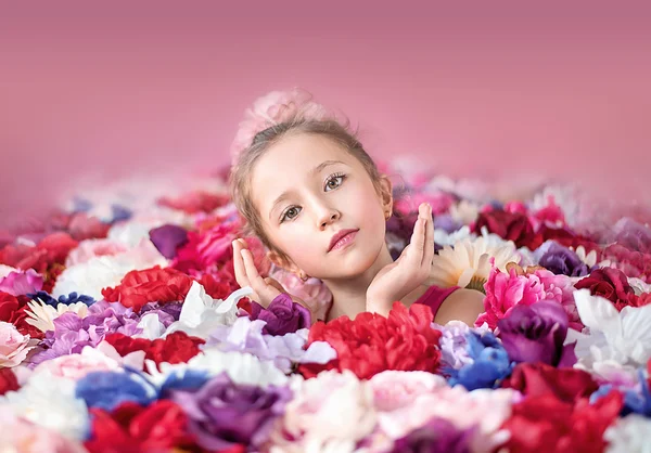 Menina bonito com um monte de flores — Fotografia de Stock