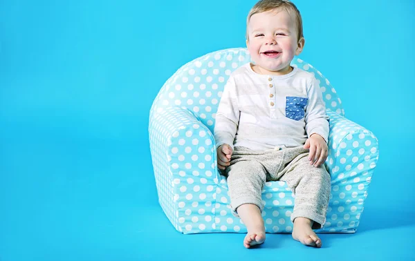 Kleiner Junge sitzt auf dem Spielzeugsessel — Stockfoto