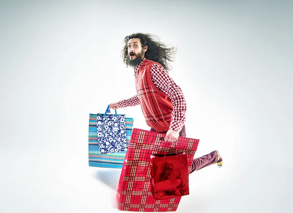 Nerd chico sosteniendo un montón de bolsas de compras —  Fotos de Stock