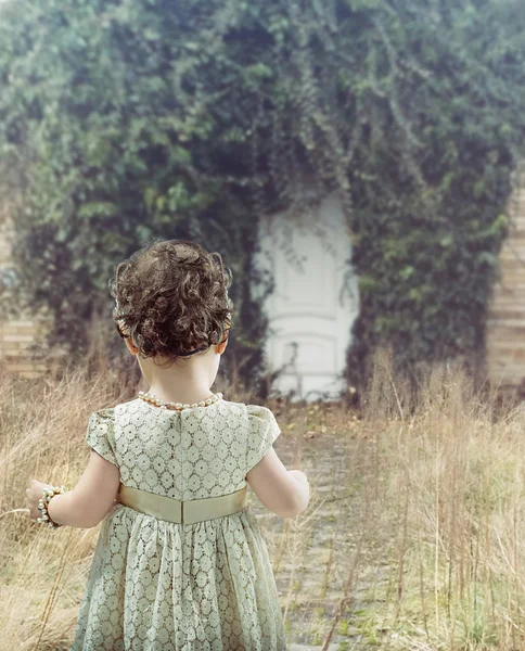 Mała dziewczynka ogląda białe drzwi — Zdjęcie stockowe