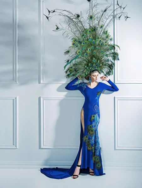 Attractive blond lady wearing a giant hat made of peacock's feat — Stock Photo, Image