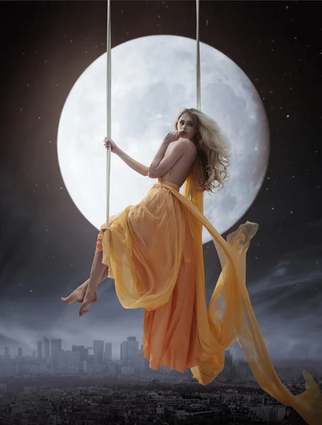 Elegante vrouw over grote maan achtergrond — Stockfoto