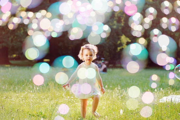 Портрет маленької дівчинки, що грає в мильні бульбашки — стокове фото