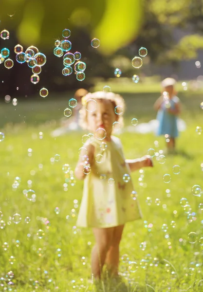 Adorables enfants soufflant les bulles de savon — Photo