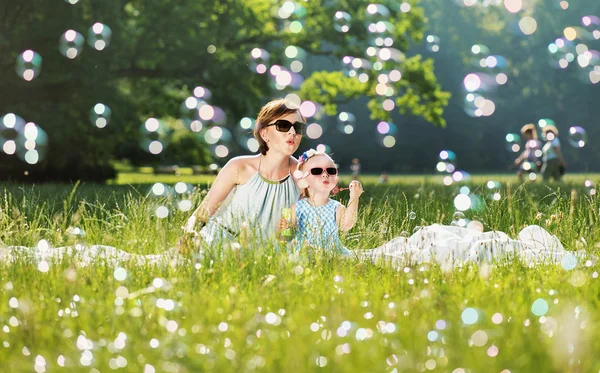 Mãe e filha tempo de família, soprando bolhas de sabão — Fotografia de Stock
