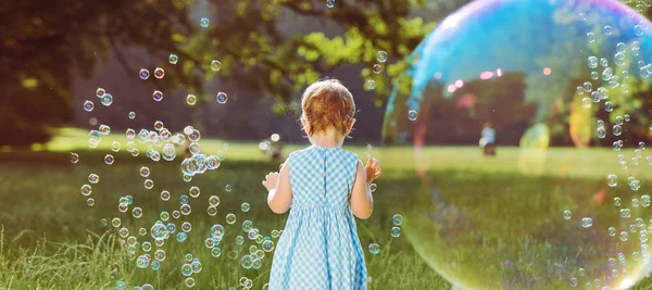 Aranyos kis lány játszik a szappanbuborékok — Stock Fotó