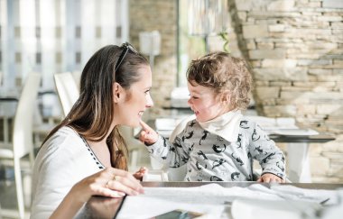 Restoranda oturan küçük kızıyla birlikte güzel anne