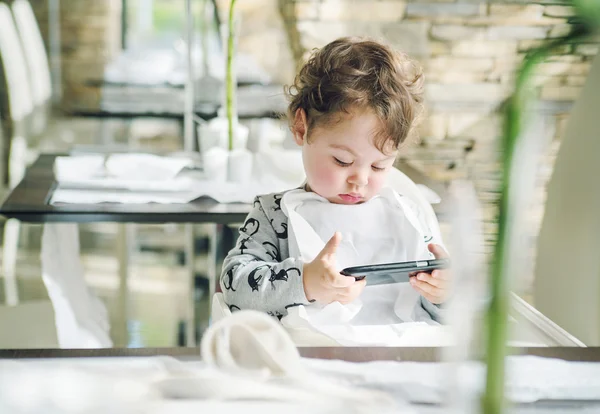 Şirin çocuk oyunları a smartphone ile oynamak — Stok fotoğraf