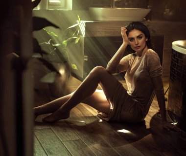 Egzotik bir bitkiyle esmer bir kadının yakın plan portresi.