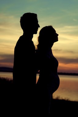 Onun hamile eşi sarılma adam silüeti