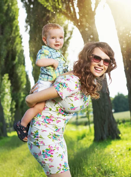 Bruna signora portando il suo bambino — Foto Stock