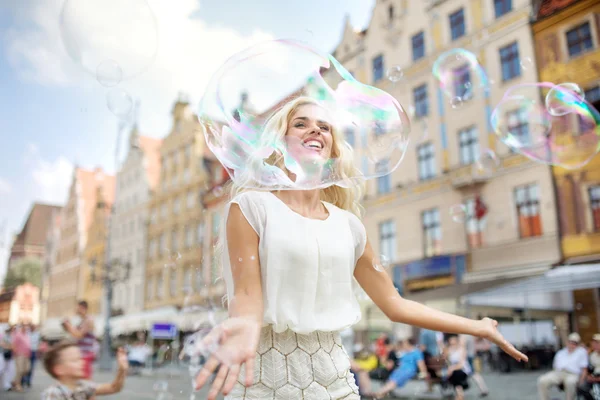 Veselá dívka, hledá prostřednictvím obrovské bubliny — Stock fotografie