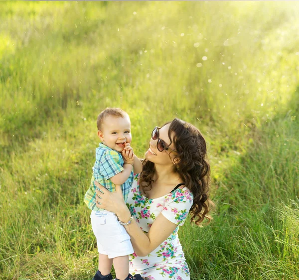 Morena mãe carregando seu lindo filho — Fotografia de Stock