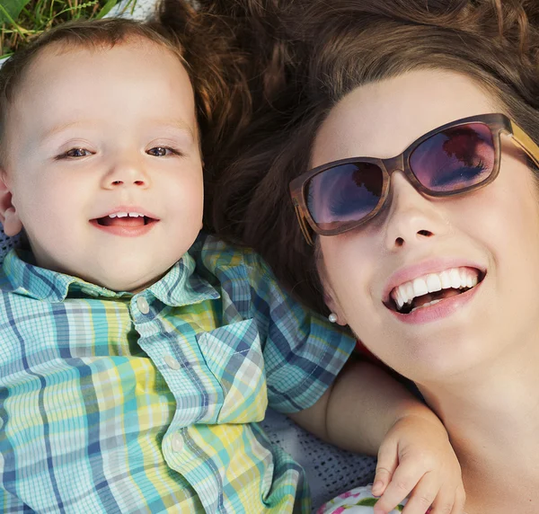 Aantrekkelijke moeder liggend op de deken met haar baby — Stockfoto