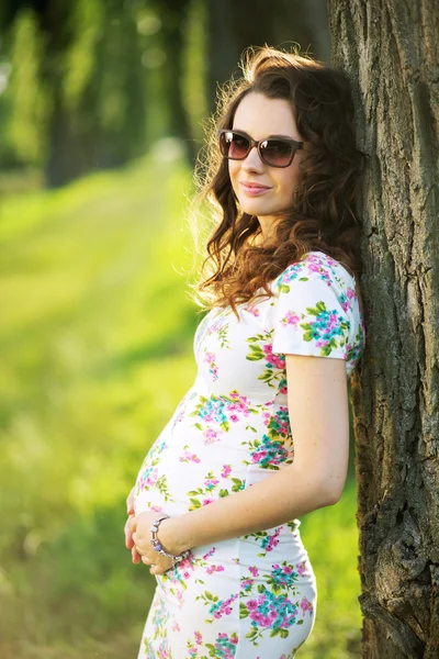 Meravigliosa donna incinta appoggiata all'albero — Foto Stock