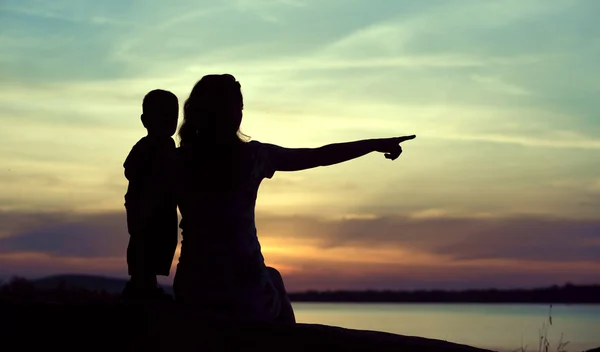 Siluetas oscuras de la madre con el niño — Foto de Stock