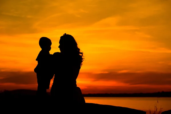 Silhouette di una giovane madre con il suo bambino — Foto Stock