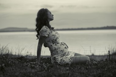 Çok güzel hamile kadın çim üzerinde yalan