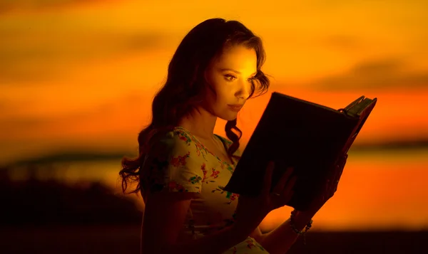 Encantadora mujer leyendo libro brillante — Foto de Stock