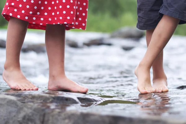 Niños empapando los pies en un arroyo — Foto de Stock