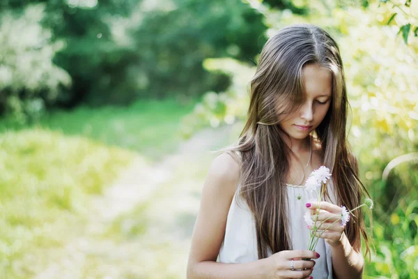 Menina calma segurando flor selvagem — Fotografia de Stock