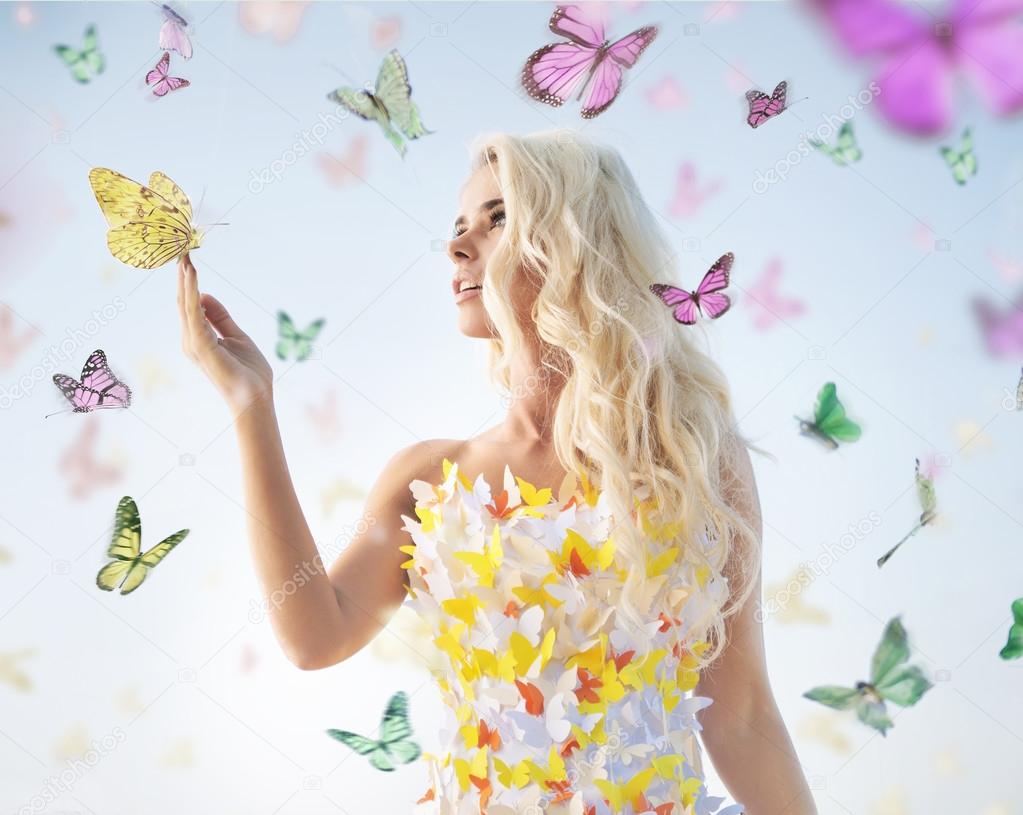 Attractive delicate blonde playing with butterflies