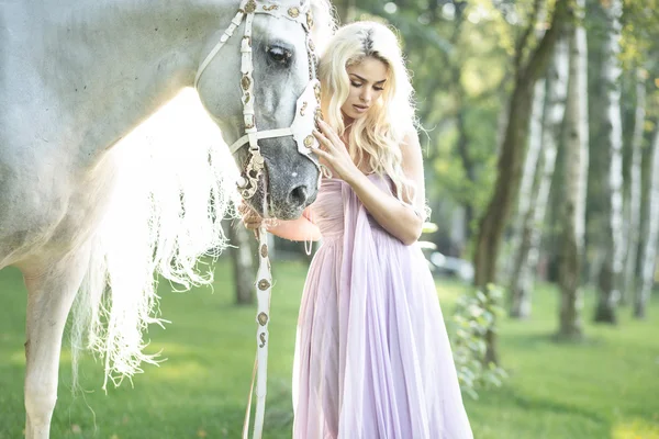 Blond leuke vrouw met een paard — Stockfoto